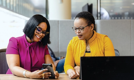 Two women in a conversation, looking at a phone