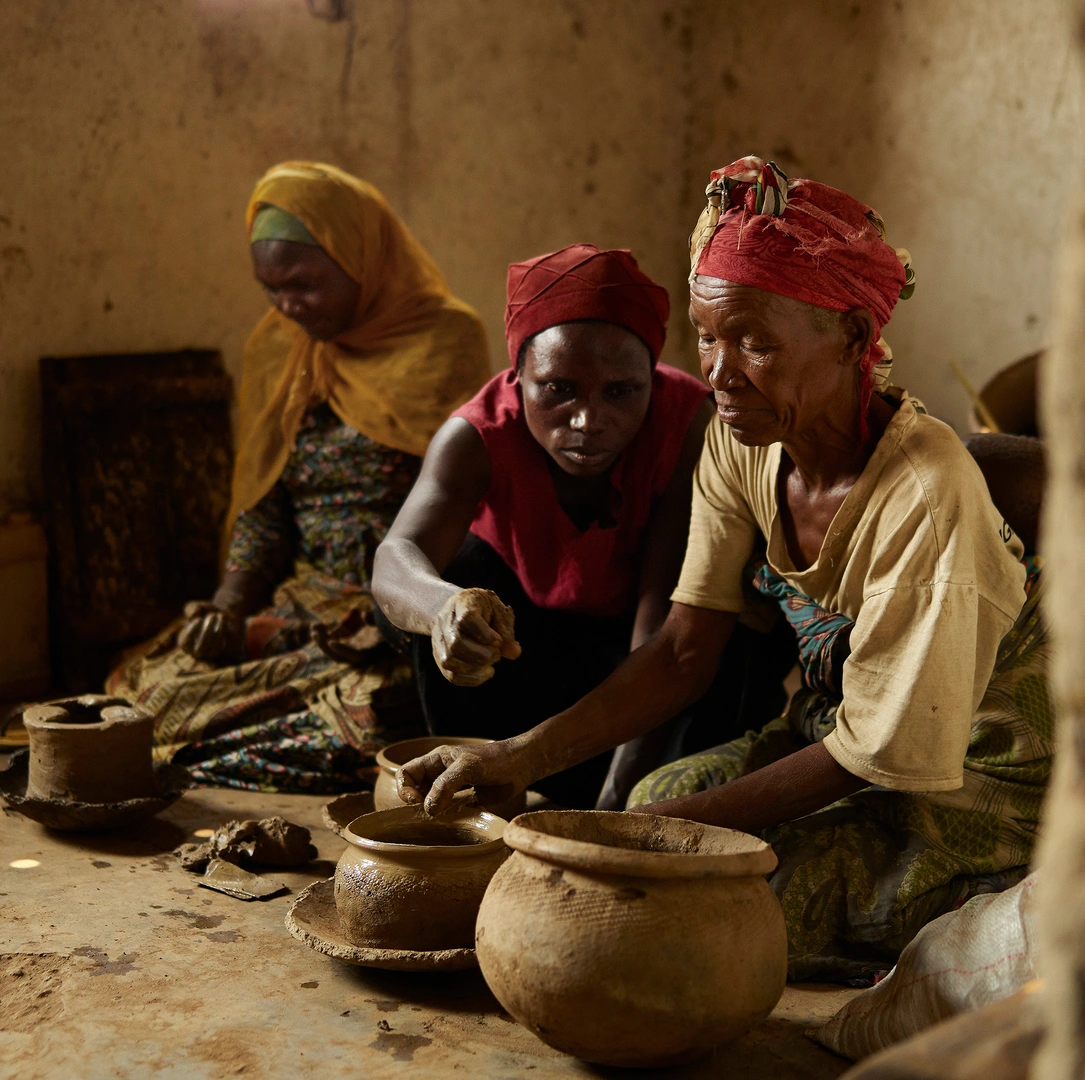 Three women making ceramic pots in Rwanda